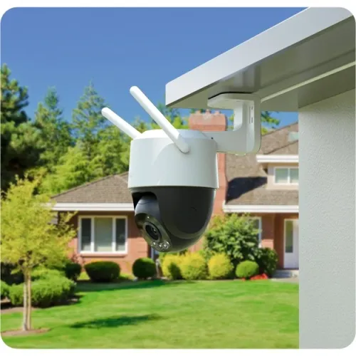 IMOU Cruiser SC 4G 3K outdoor pan-and-tilt camera in white mounted under the eaves of a house, seen from below at an angle with the garden behind